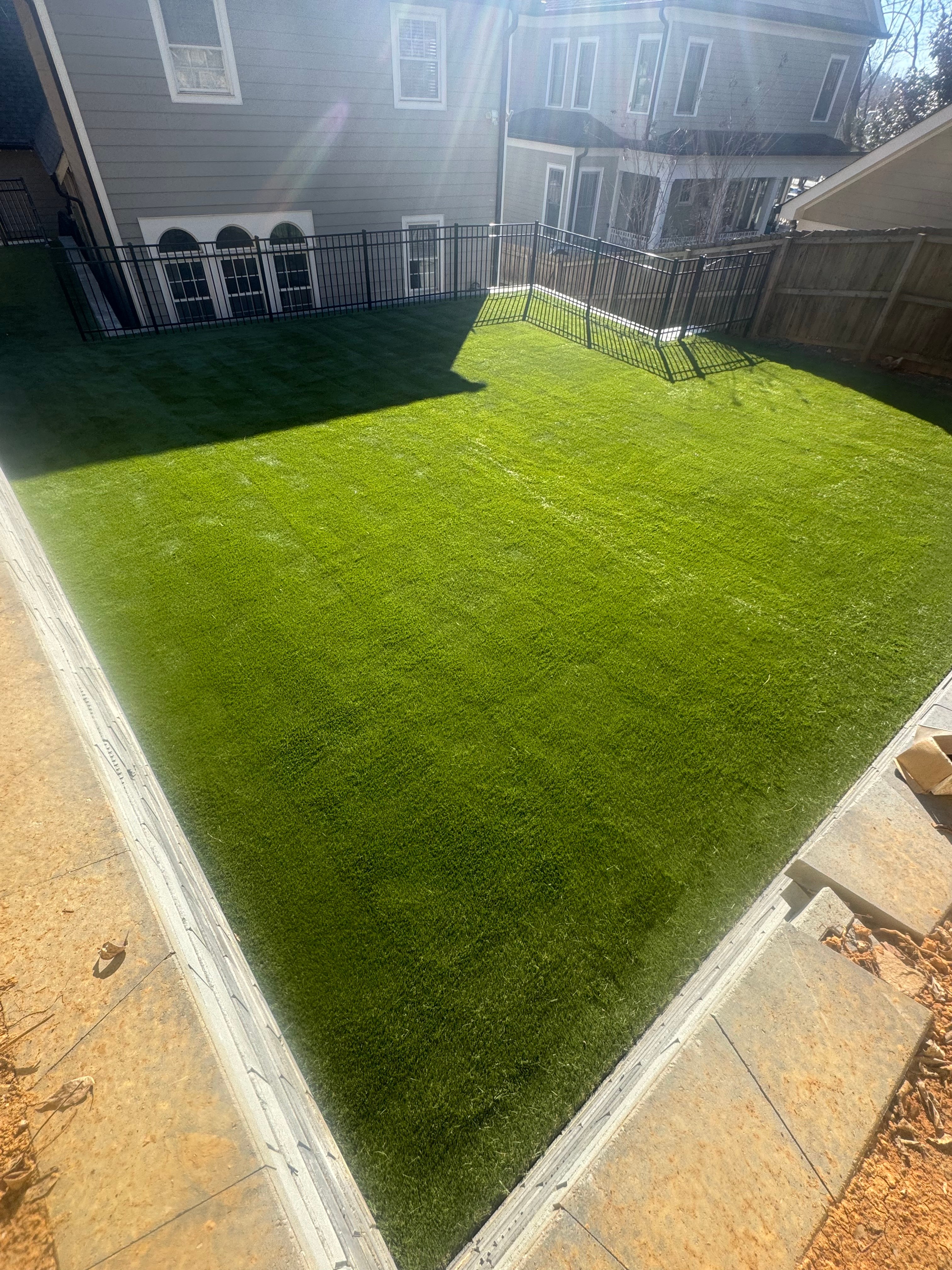 A clean and simple rectangular turf installation in an enclosed backyard.