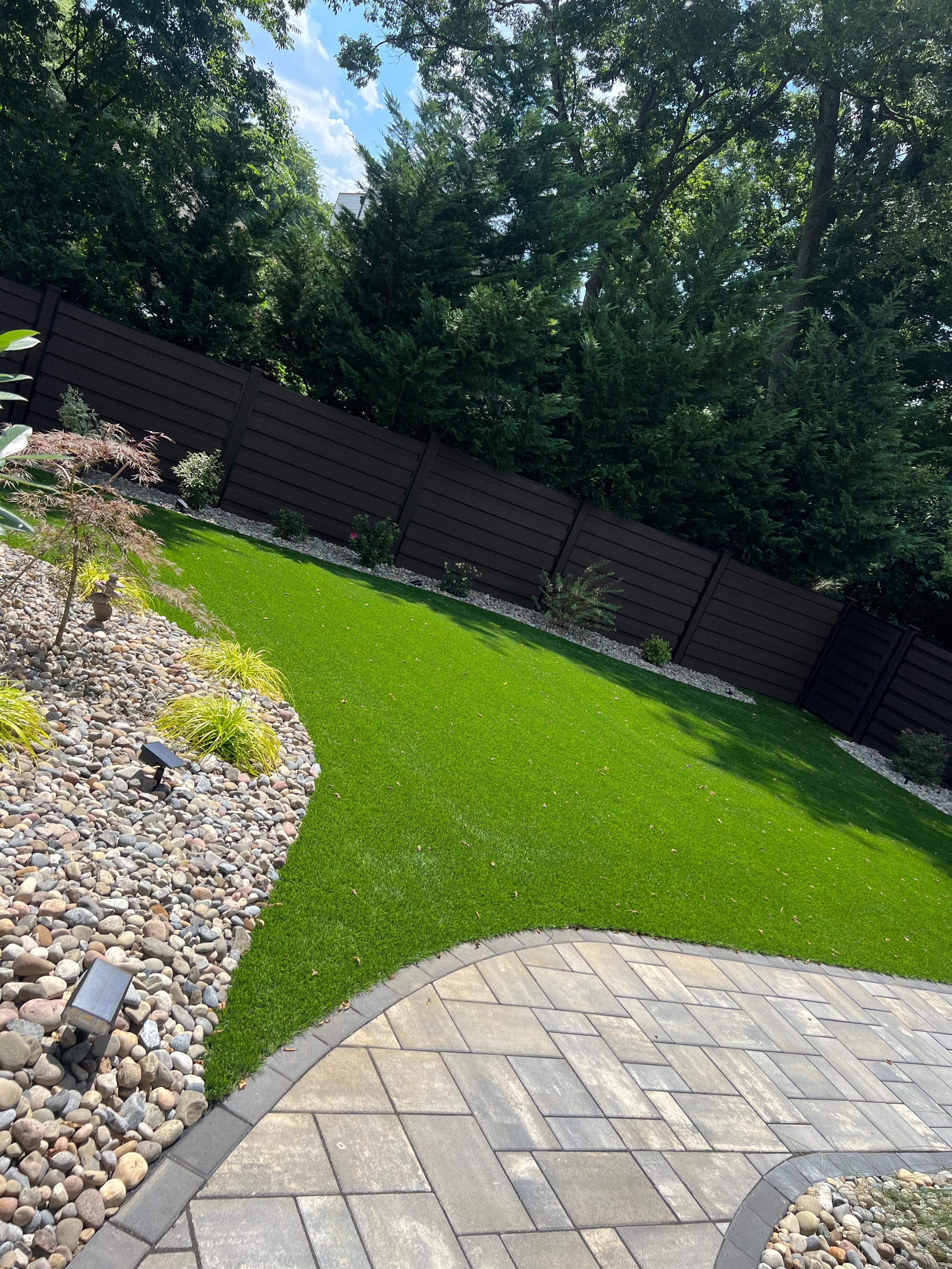 A beautiful turf lawn seamlessly integrated with a paver patio.