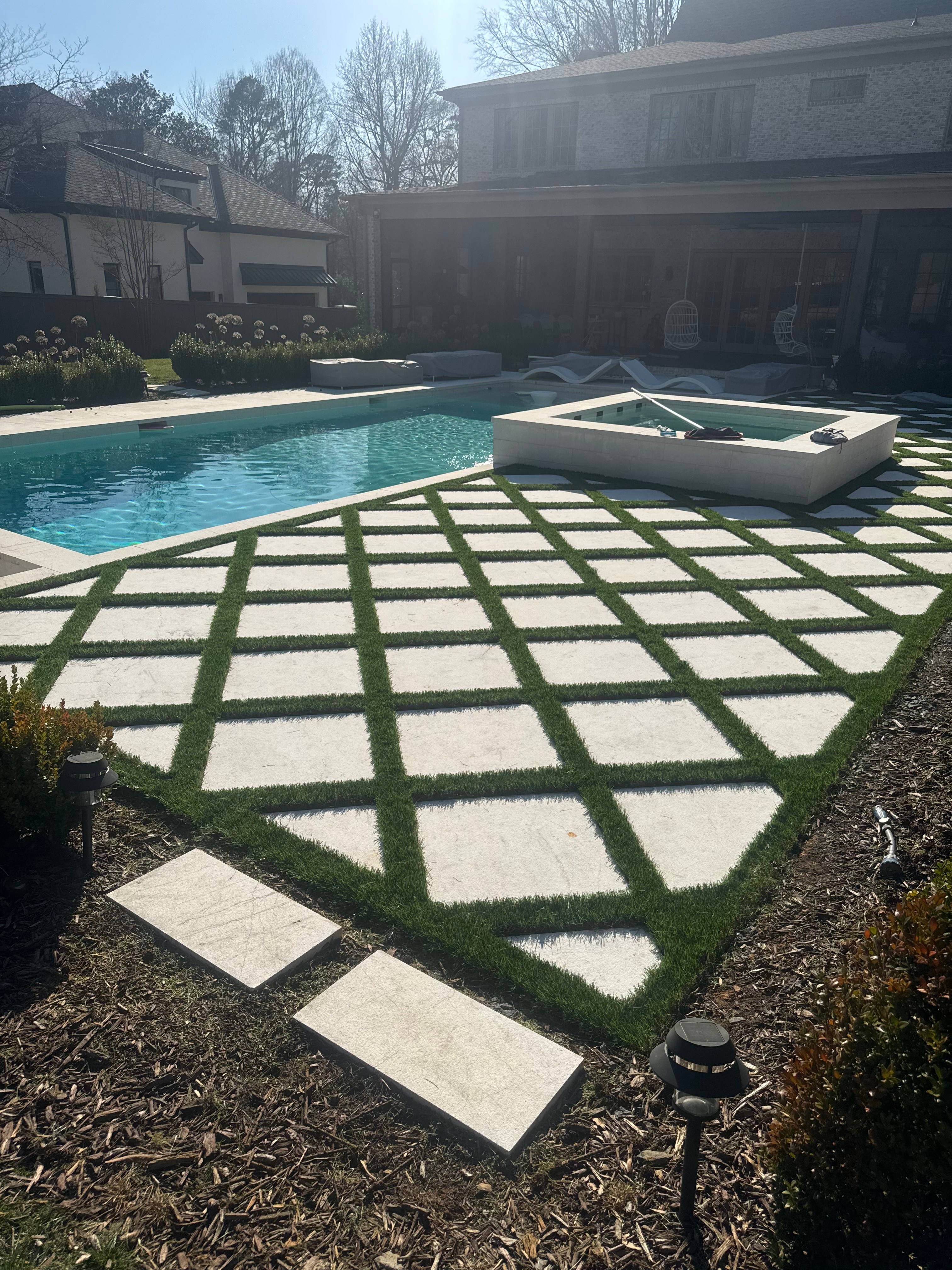 Complex turf shapes cut perfectly to fit around a modern pool deck.